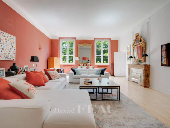 Salon spacieux d'un appartement à Aix-en-Provence avec canapés blancs et murs roses.