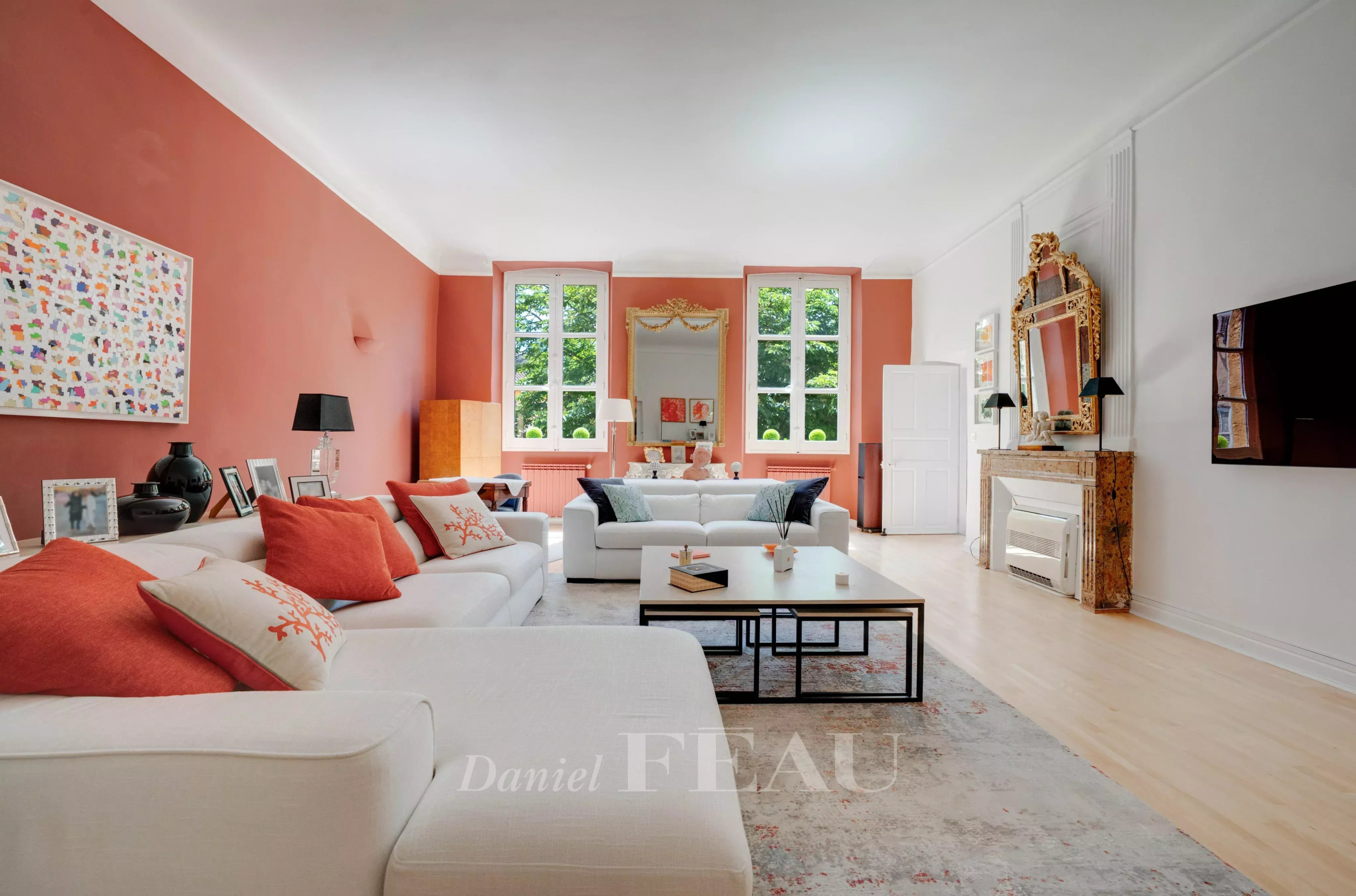 Salon d’un appartement à Aix-en-Provence Salon spacieux d'un appartement à Aix-en-Provence avec canapés blancs et murs roses.