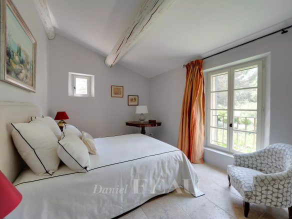 Chambre d'un mas ancien à Aix-en-Provence avec des murs clairs et des éléments décoratifs.