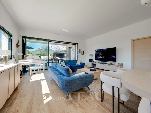 Intérieur d'une maison contemporaine à Aix-en-Provence avec salon lumineux et cuisine américaine.