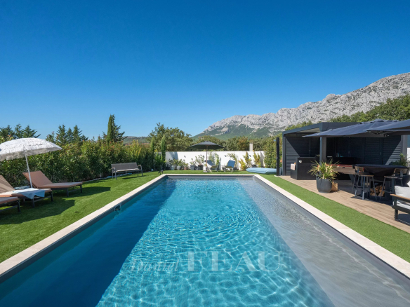 Piscine et espace extérieur d'une maison contemporaine à Aix-en-Provence, avec vue sur la montagne.