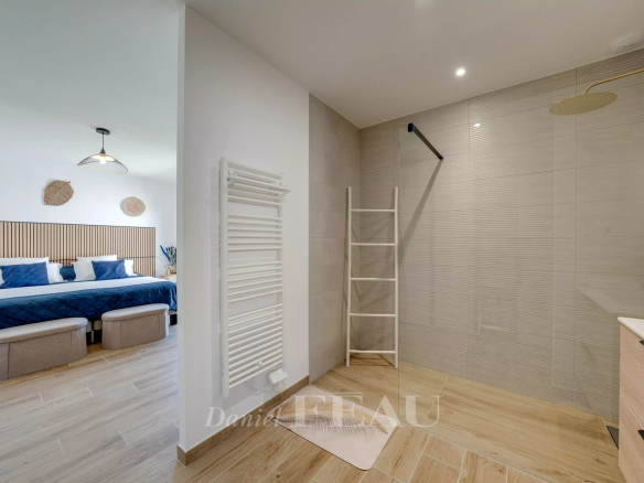 Salle de bain moderne avec douche et chambre à coucher attenante dans une maison contemporaine.