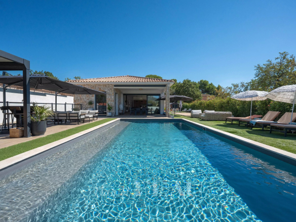 Maison contemporaine avec piscine à Aix-en-Provence, vue sur le jardin et parasols.