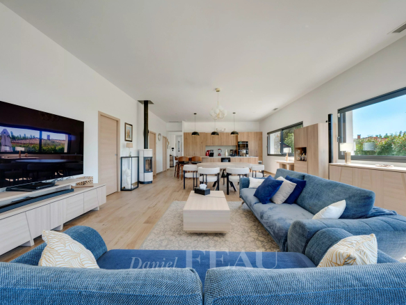 Intérieur d'une maison contemporaine à Aix-en-Provence, avec salon, cuisine américaine et grandes fenêtres.