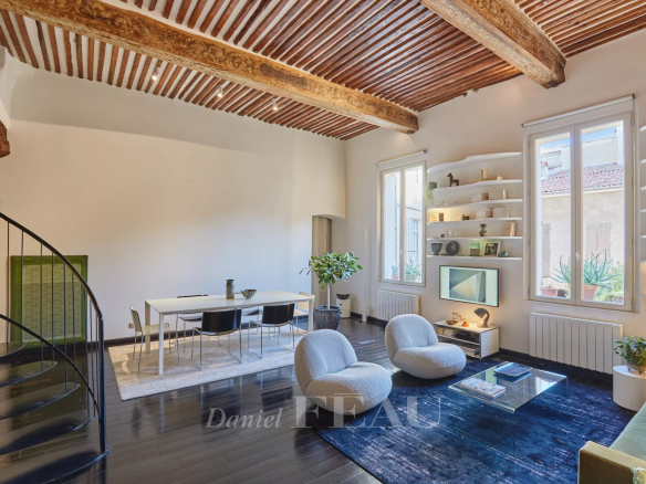 Living room of an apartment in the historic center of Aix-en-Provence with exposed beams and modern furniture.