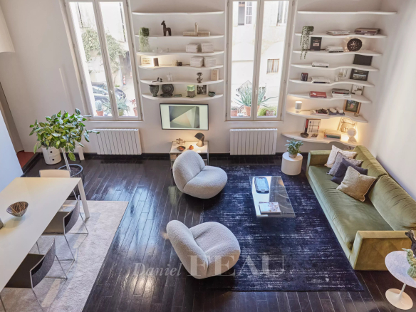 Living room of a renovated apartment in Aix-en-Provence with modern furniture and natural lighting.