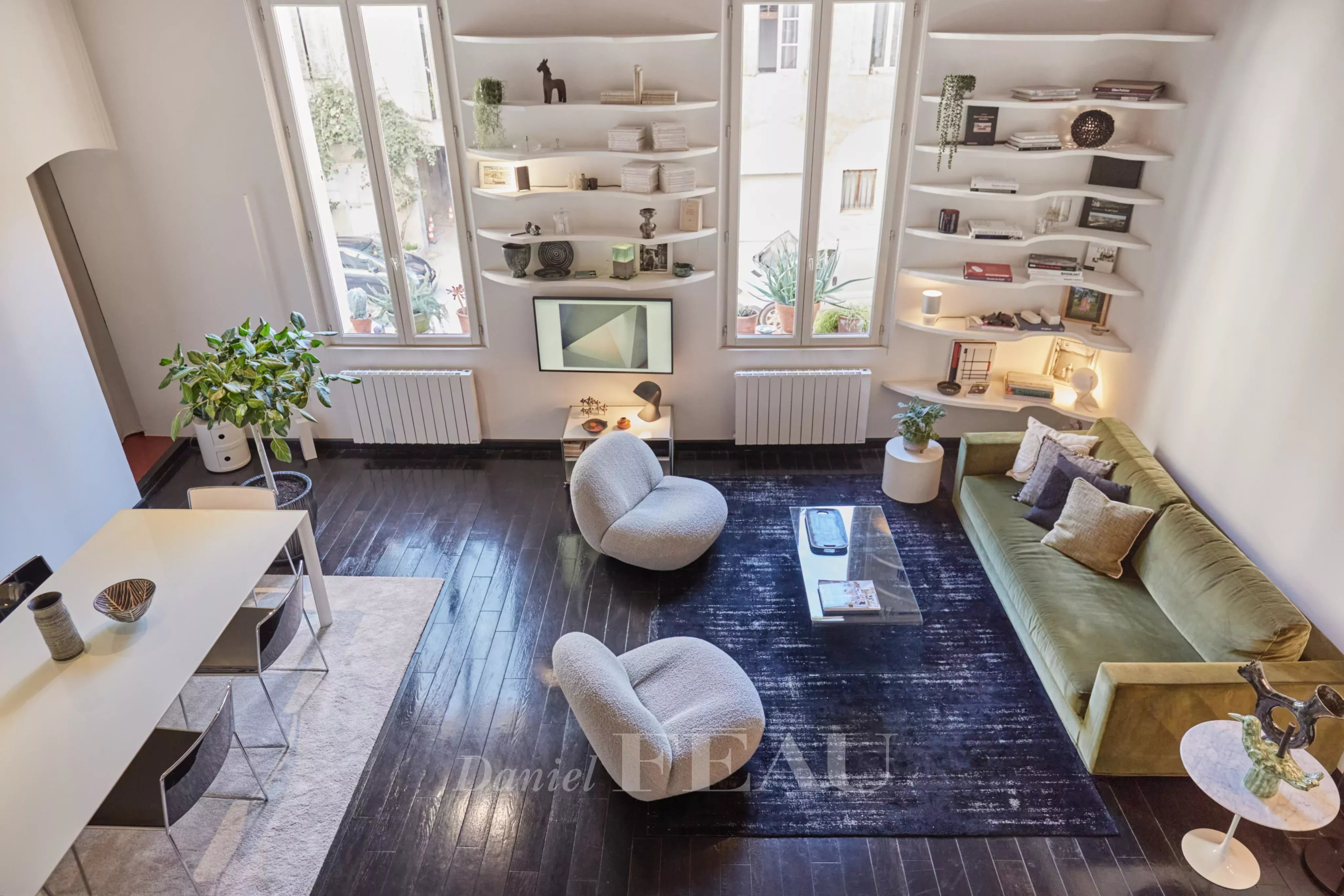 Living room of a renovated apartment in Aix-en-Provence with modern furniture and natural lighting.