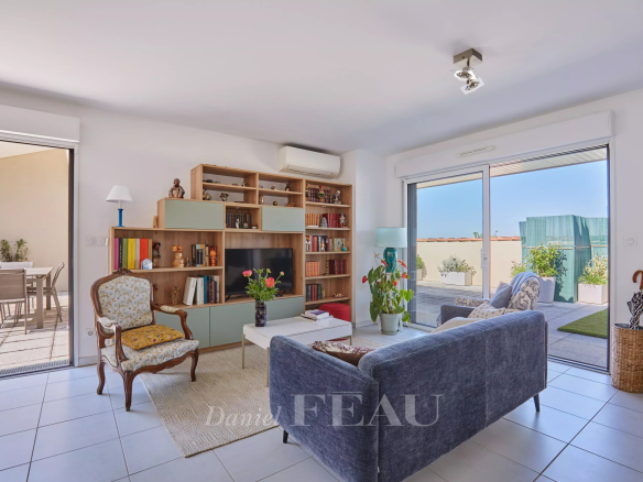 Intérieur d'un appartement à Aix-en-Provence avec salon lumineux et accès à une terrasse.