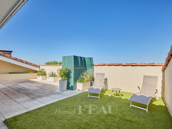Terrasse d'un appartement à Aix-en-Provence avec chaises longues et vue dégagée.