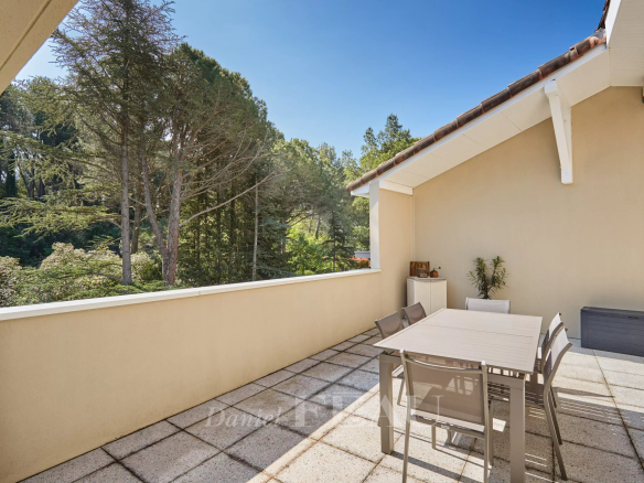 Terrasse d'un appartement à Aix-en-Provence avec mobilier de jardin et vue sur la nature.