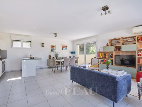 Intérieur d'un appartement moderne avec salon, salle à manger et accès à une terrasse.