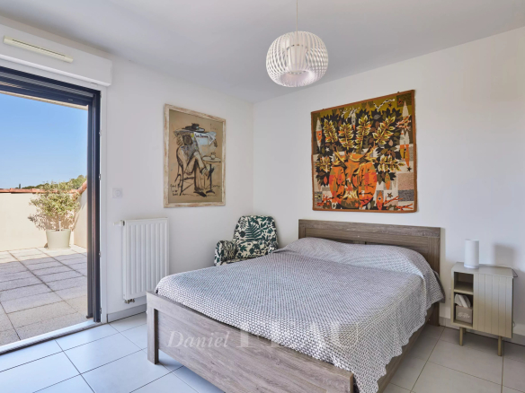 Chambre d'appartement avec terrasse à Aix-en-Provence, décorée de tableaux et mobilier moderne.