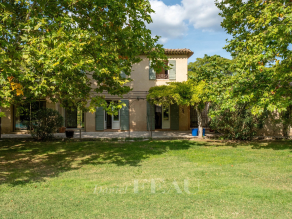 Bastide provençale dans un parc paysager à Aix-en-Provence, entourée d'arbres.