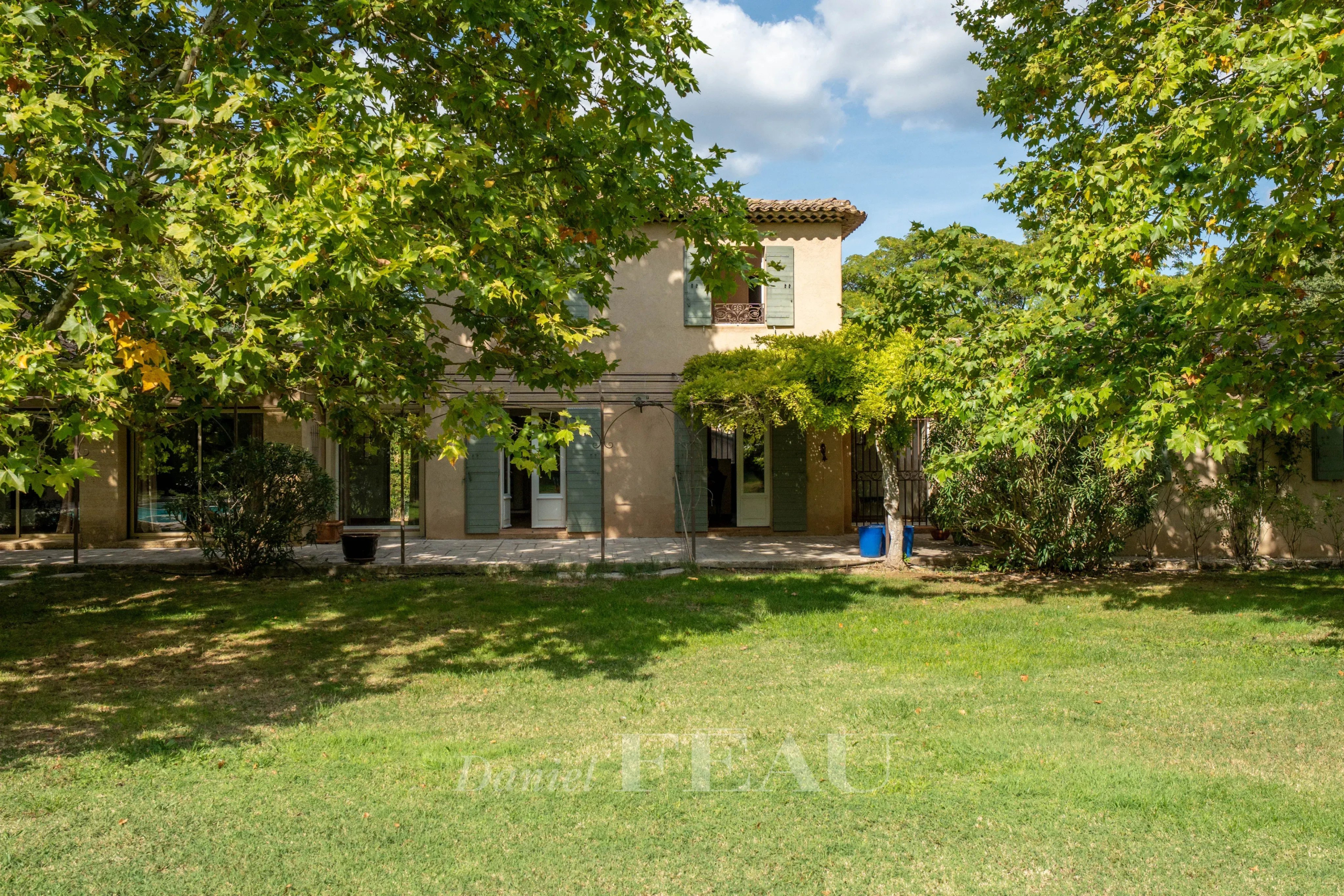 Bastide provençale dans un parc paysager à Aix-en-Provence, entourée d'arbres.