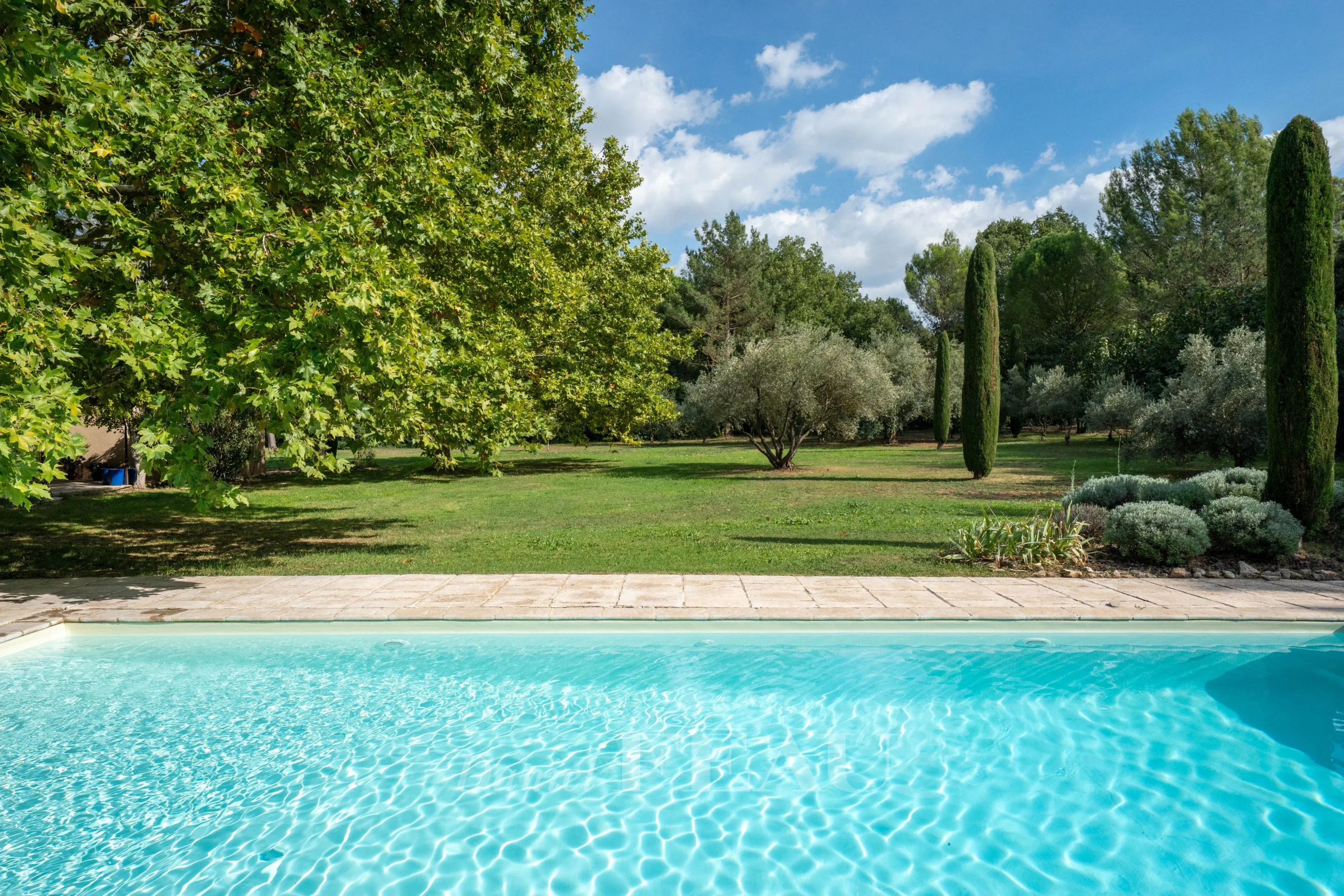 Vue d'une piscine avec un parc paysager en arrière-plan, Aix-en-Provence.