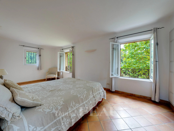 Chambre spacieuse avec fenêtres ouvertes sur un parc verdoyant, à Aix-en-Provence.