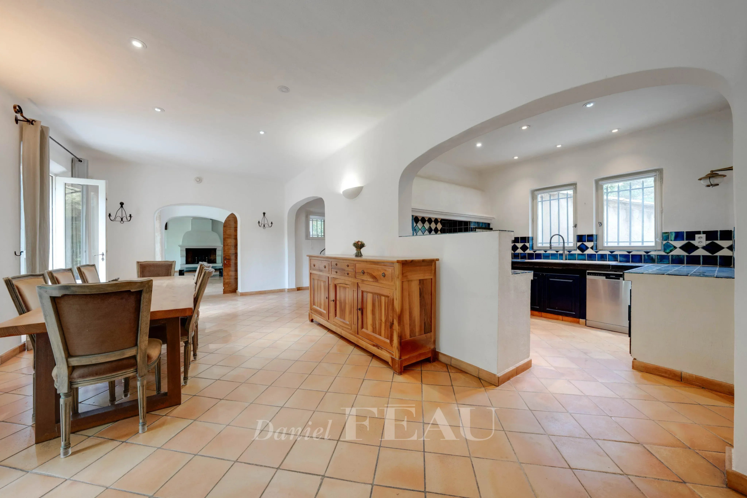 Intérieur d'une bastide provençale avec salle à manger et cuisine ouverte.