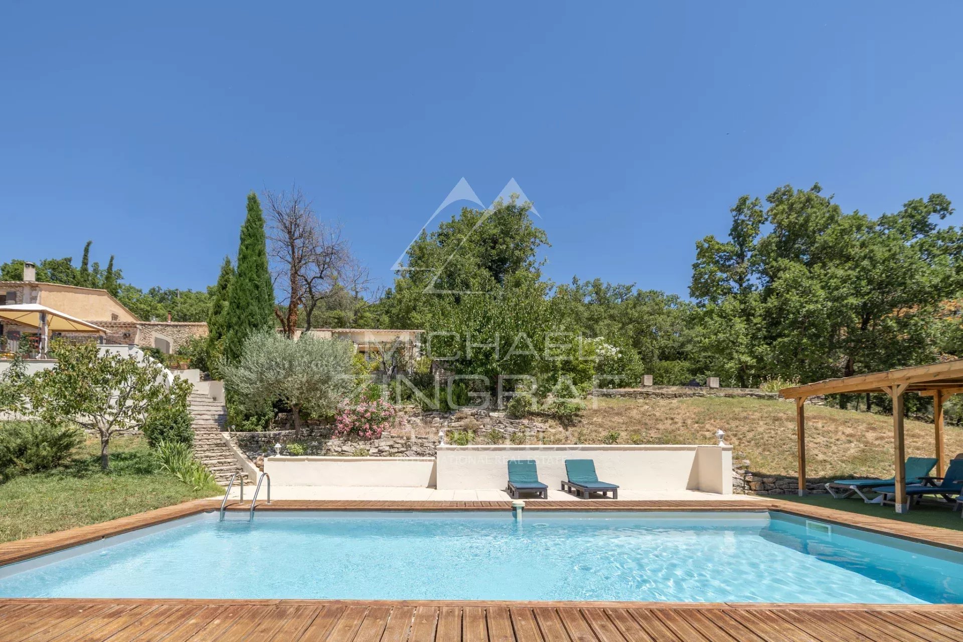 Swimming pool surrounded by greenery in a spacious property near Gordes, Luberon.