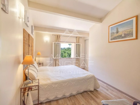 Bright room with double bed and view of the wooded park.
