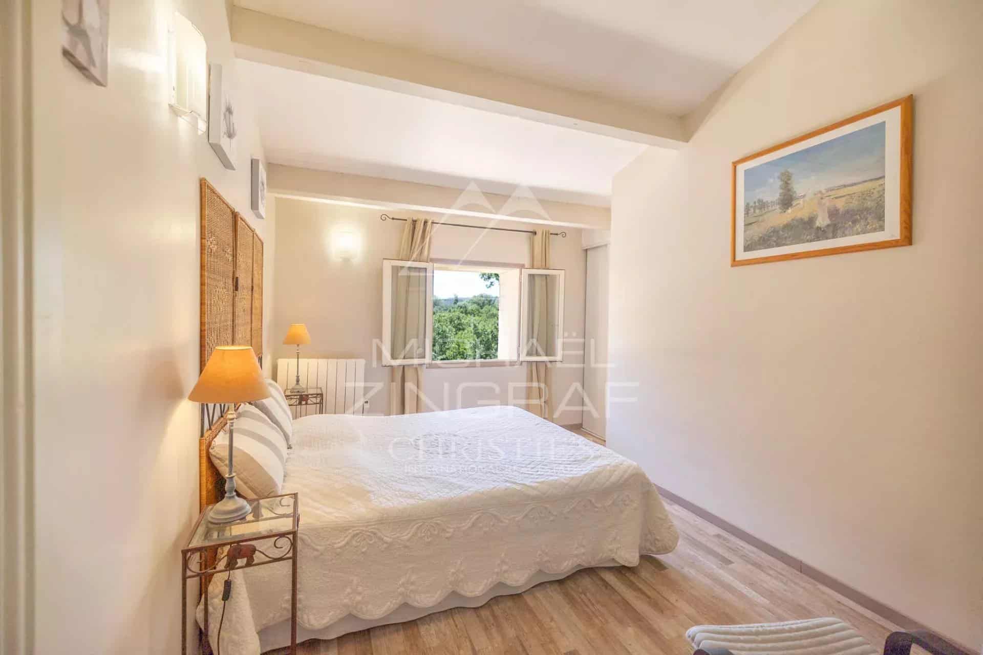 Bright room with double bed and view of the wooded park.