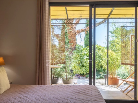 View of a bright veranda with access to a green garden, in Gordes, Luberon.