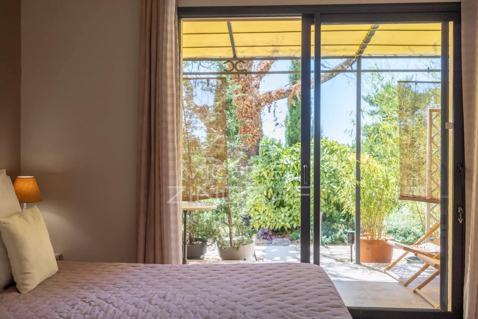 View of a bright veranda with access to a green garden, in Gordes, Luberon.