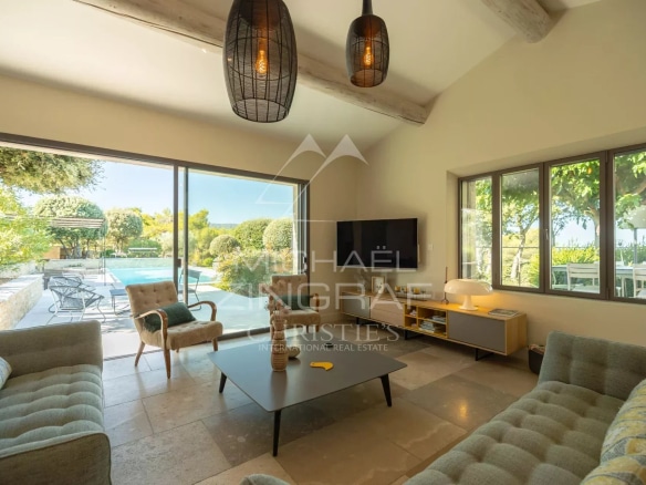 Interior of a Provençal house with a bright living room and a view of the swimming pool