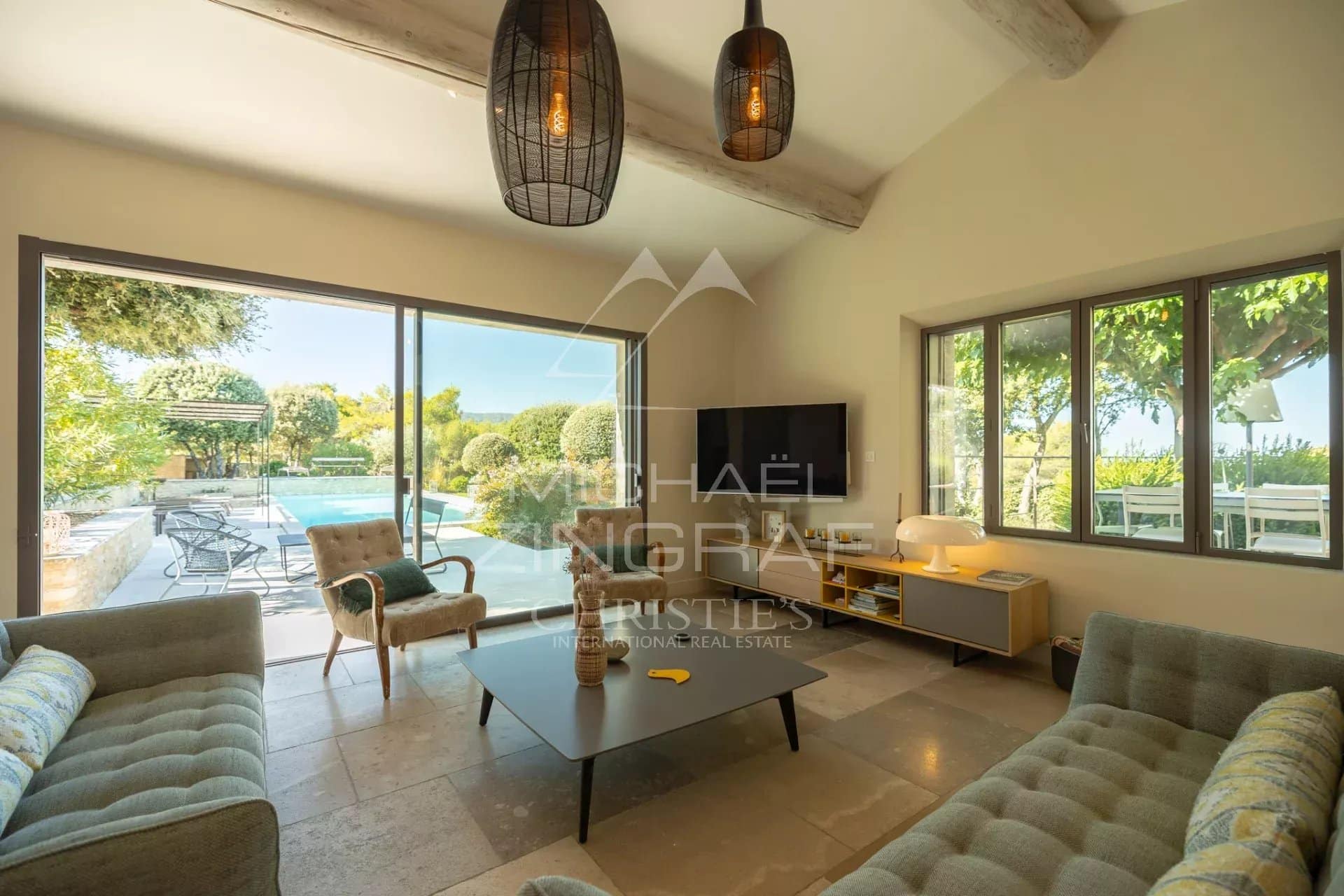 Interior of a Provençal house with a bright living room and a view of the swimming pool