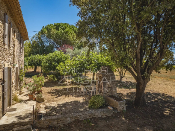 Mas XVIIIe authentique à rénover avec vue sur le Luberon, entouré d'arbres et de verdure.