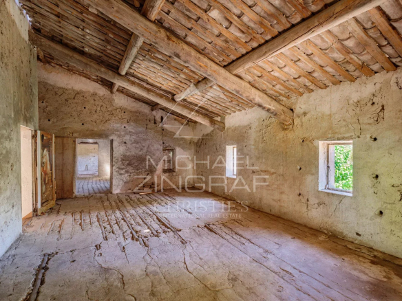 Intérieur d'un mas XVIIIe à rénover avec murs en pierre et plafond en bois, situé à Gordes.