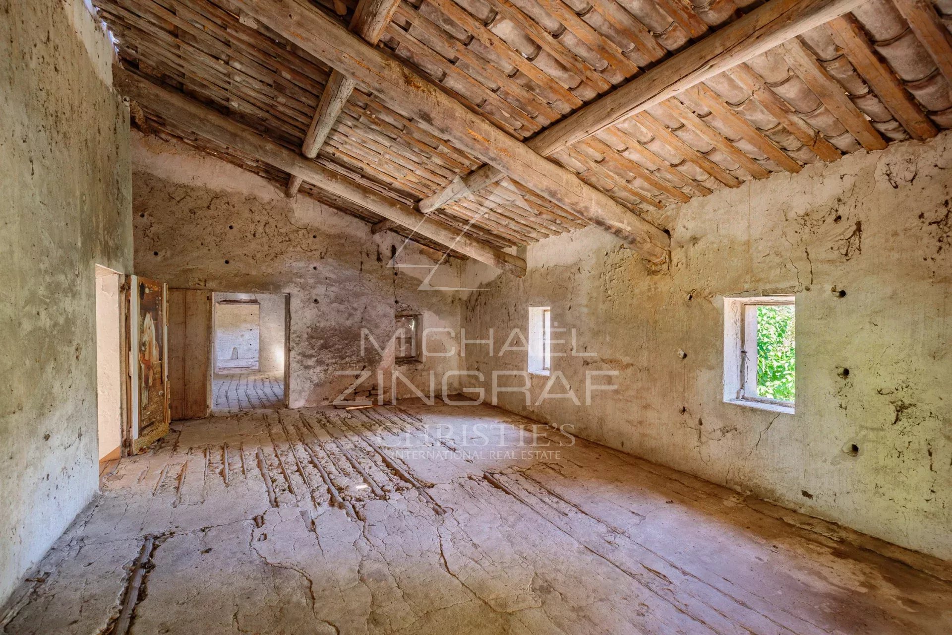 Intérieur d'un mas XVIIIe à rénover avec murs en pierre et plafond en bois, situé à Gordes.