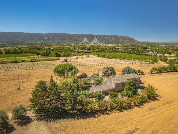 Vue aérienne d'un mas XVIIIe siècle à rénover, entouré de champs et de collines, près de Gordes.