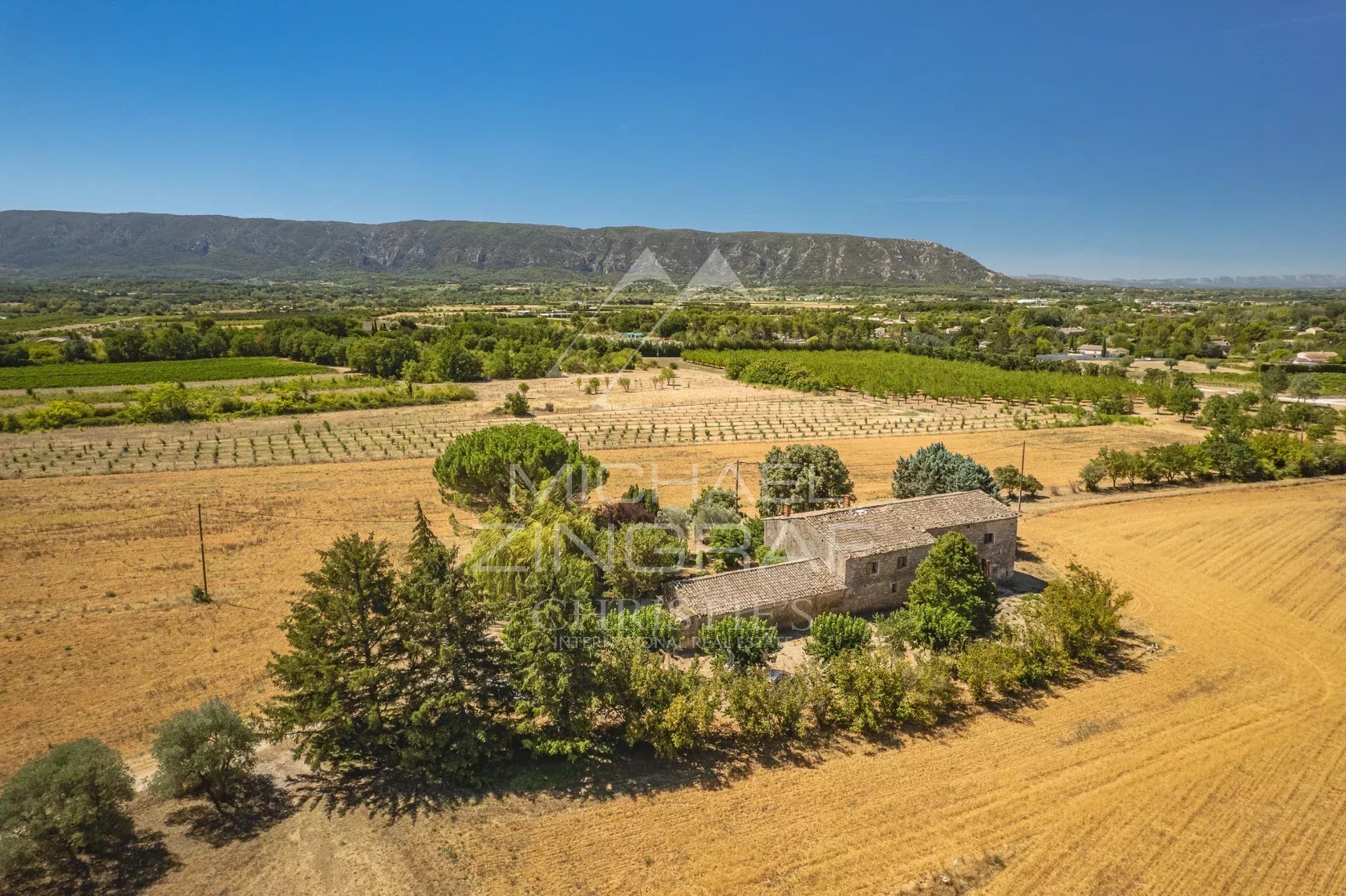 Vue aérienne d'un mas XVIIIe siècle à rénover, entouré de champs et de collines, près de Gordes.