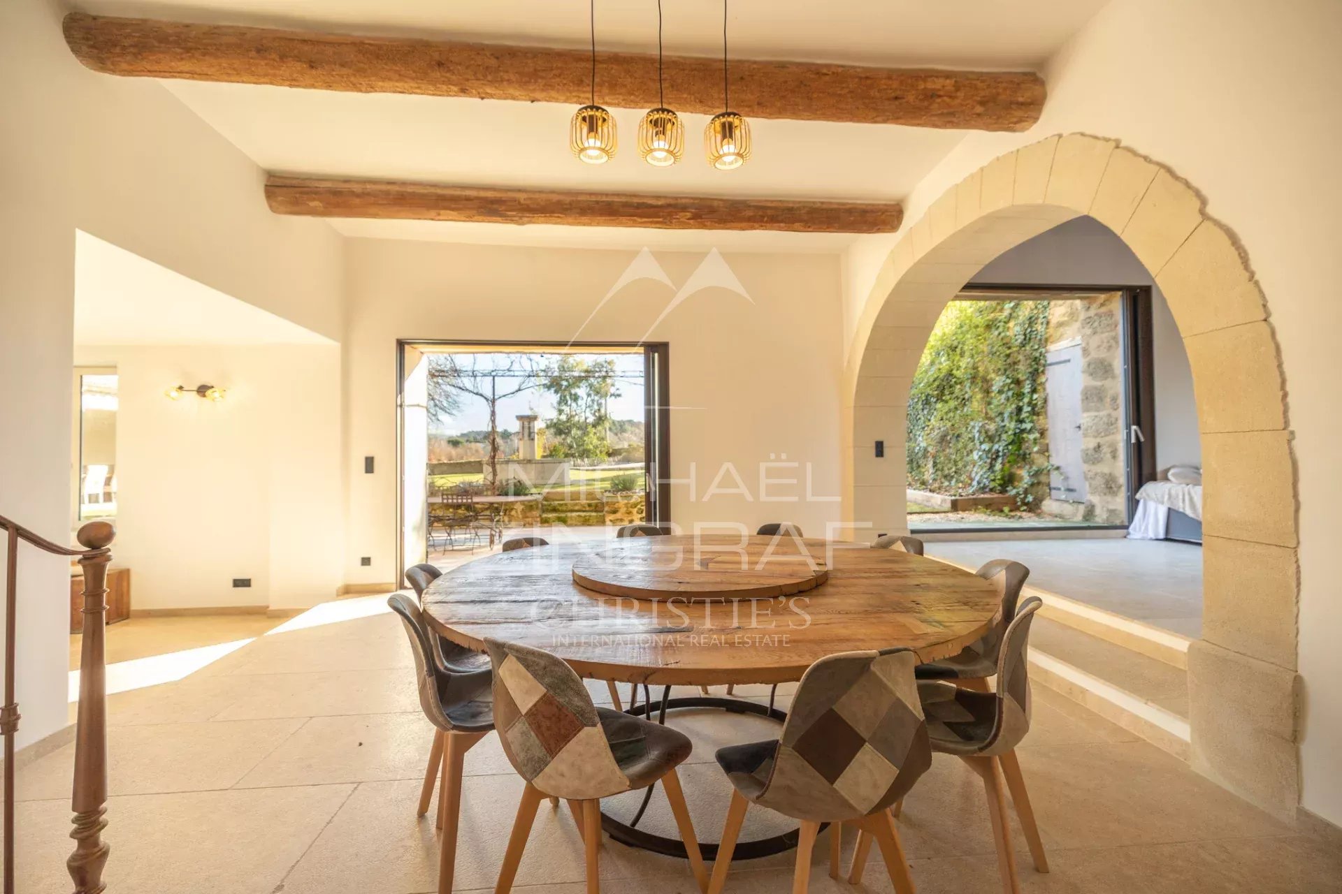 Interior of a renovated farmhouse in Oppède Interior of a renovated farmhouse with a large wooden table and chairs, bathed in light.