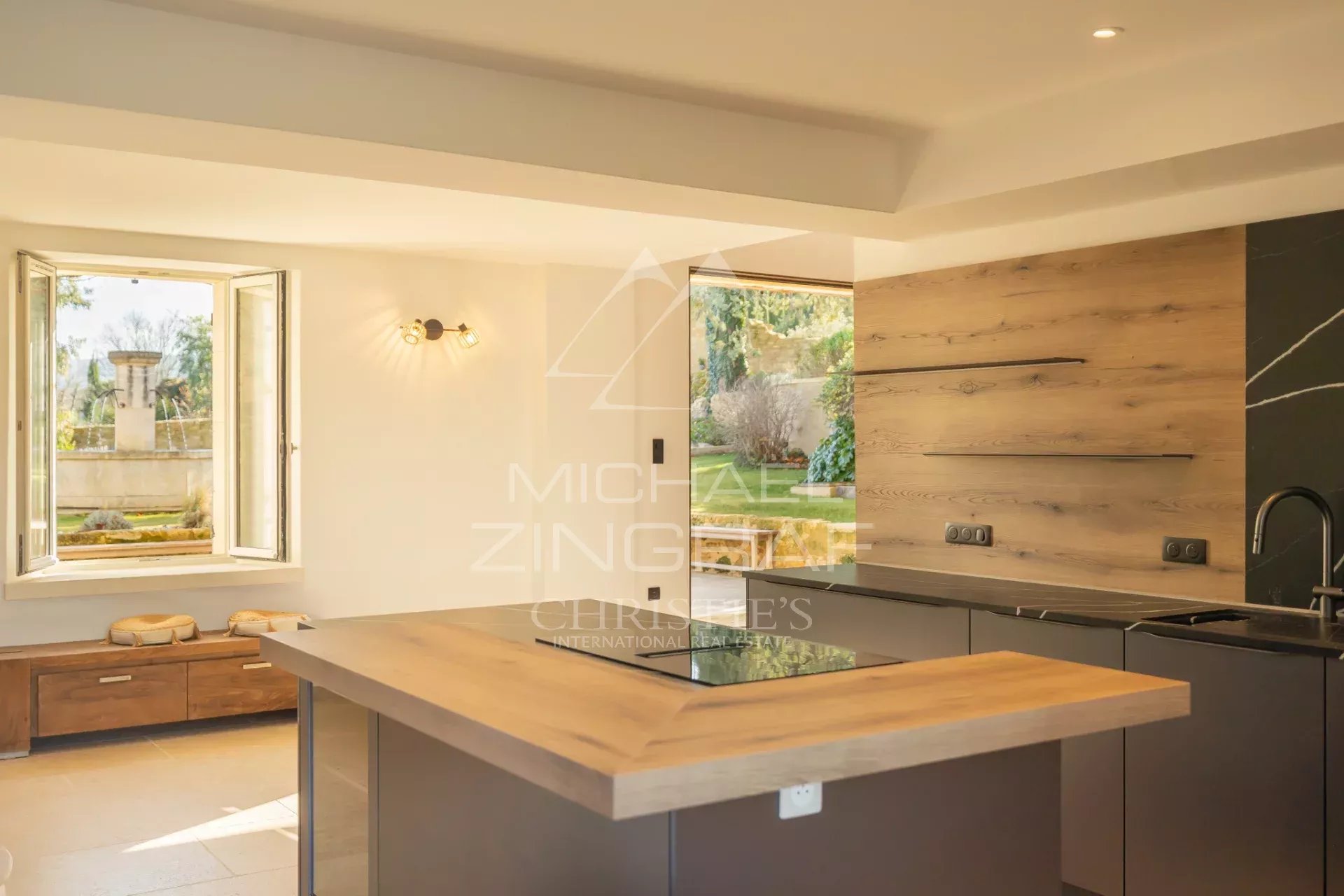 Modern kitchen in a renovated farmhouse in Oppède Interior of a modern kitchen with a wooden worktop and a window overlooking a garden.