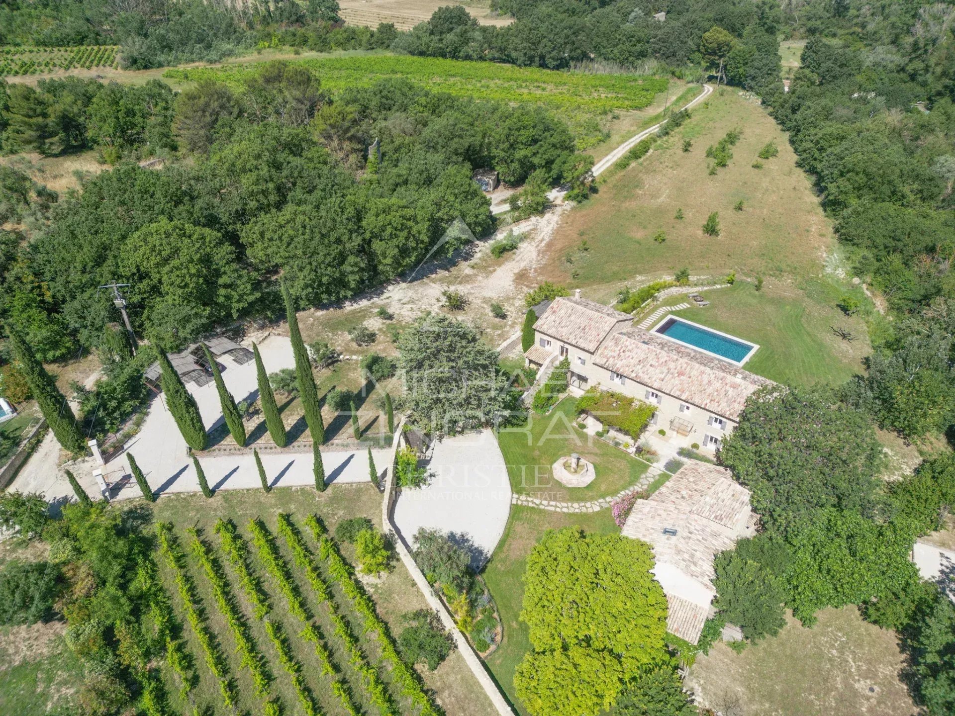Renovated farmhouse with swimming pool in Oppède Aerial view of a renovated farmhouse with swimming pool on a 2.6 hectare plot in Oppède, surrounded by vineyards and olive trees.