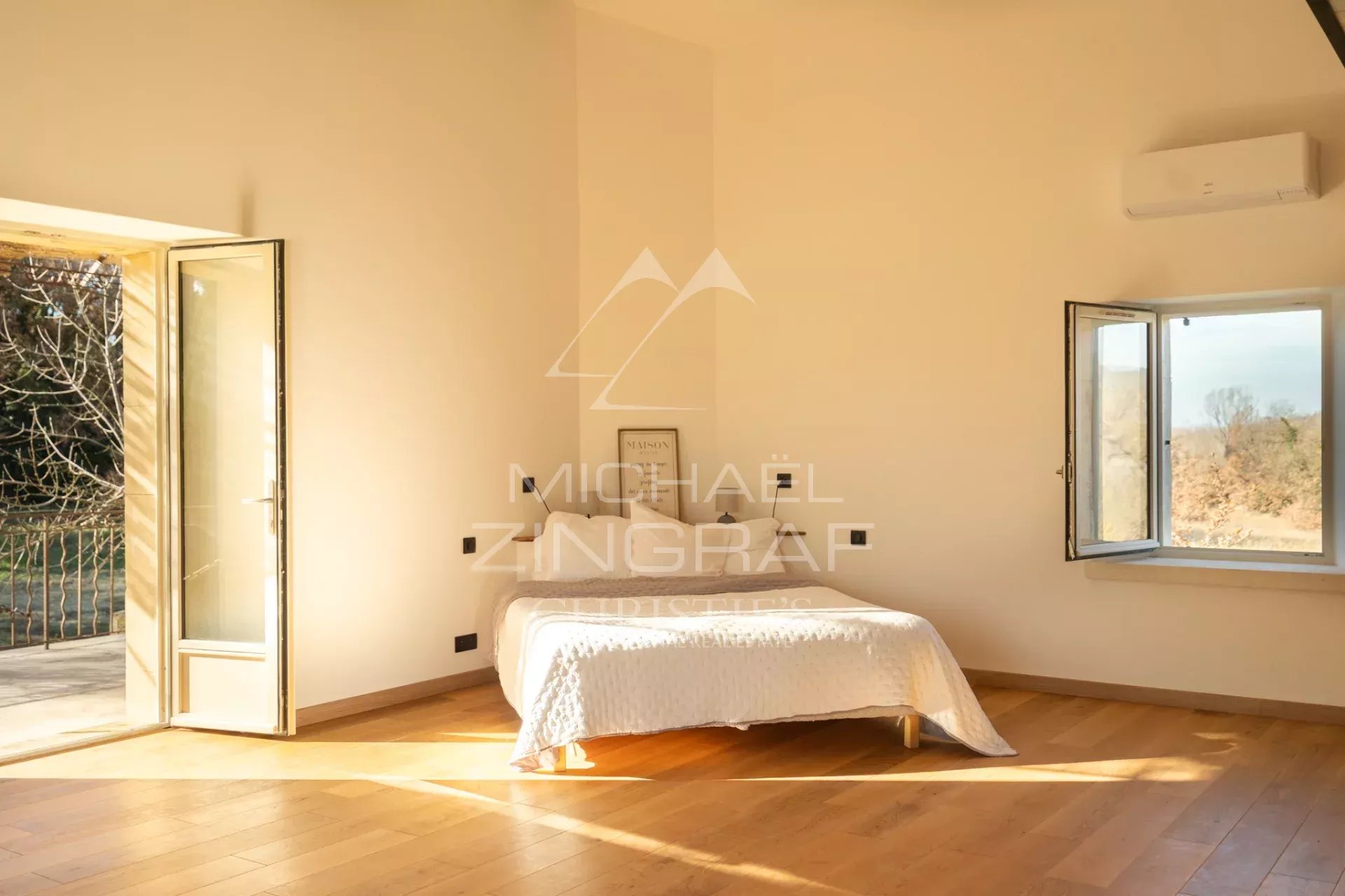 Room in a renovated farmhouse in Oppède Bright room in a renovated farmhouse in Oppède with open windows and wooden parquet flooring.