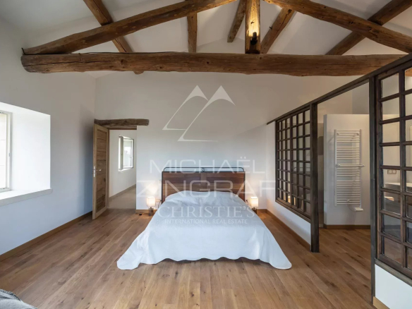 Room in a renovated farmhouse with exposed beams and parquet flooring, natural light.