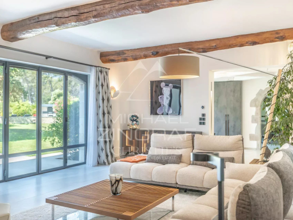 Interior of a modern house with a bright living room and large bay windows, decorated with contemporary elements.