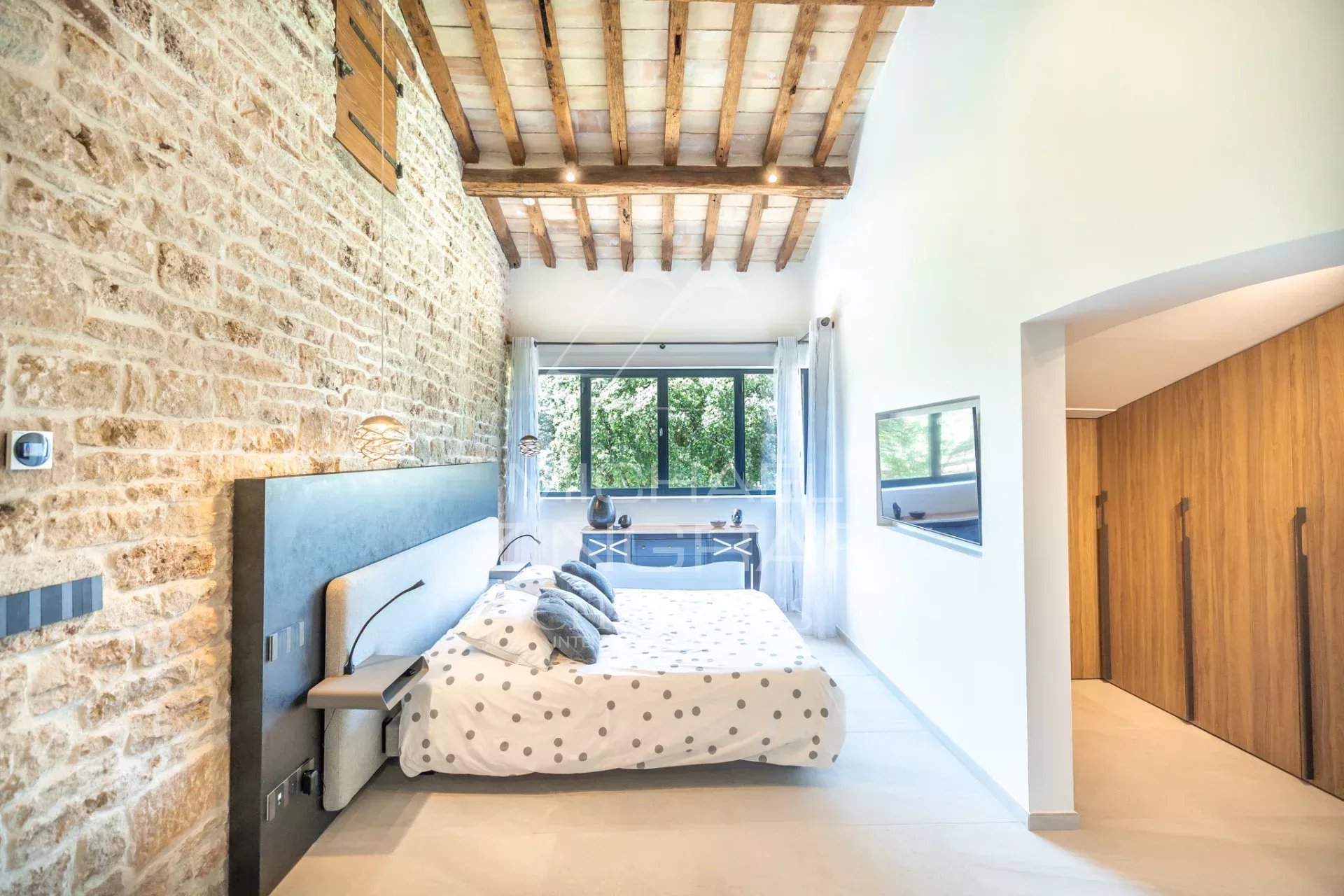 Modern room in a renovated property Modern bedroom with stone walls and wooden ceiling in a renovated property near L'Isle-sur-la-Sorgue.