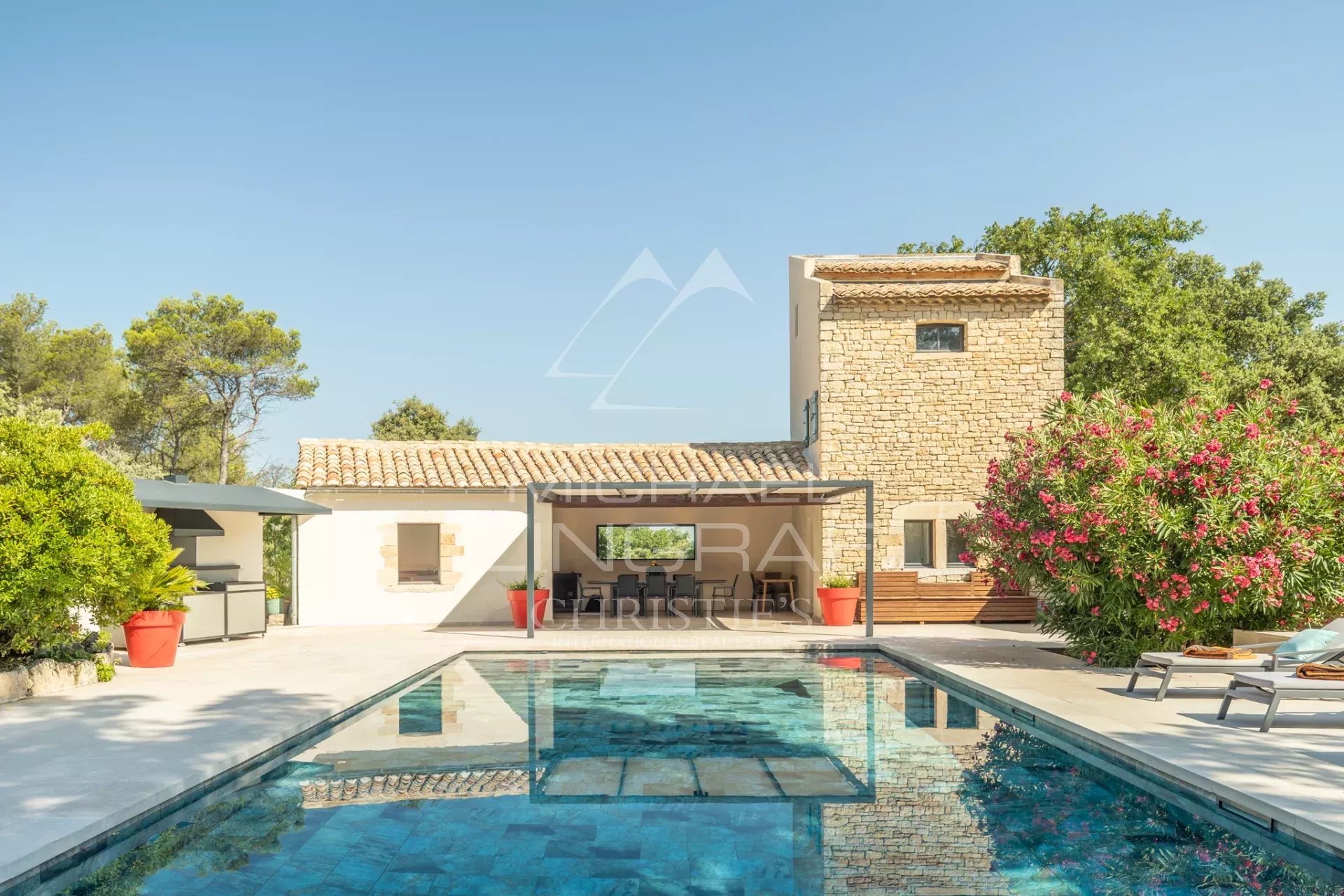 Exceptional property near L'Isle-sur-la-Sorgue View of a stone house with swimming pool and outdoor space, surrounded by greenery, near L'Isle-sur-la-Sorgue.
