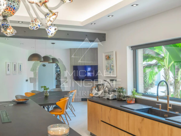 Modern kitchen interior with a black worktop and colorful chairs.
