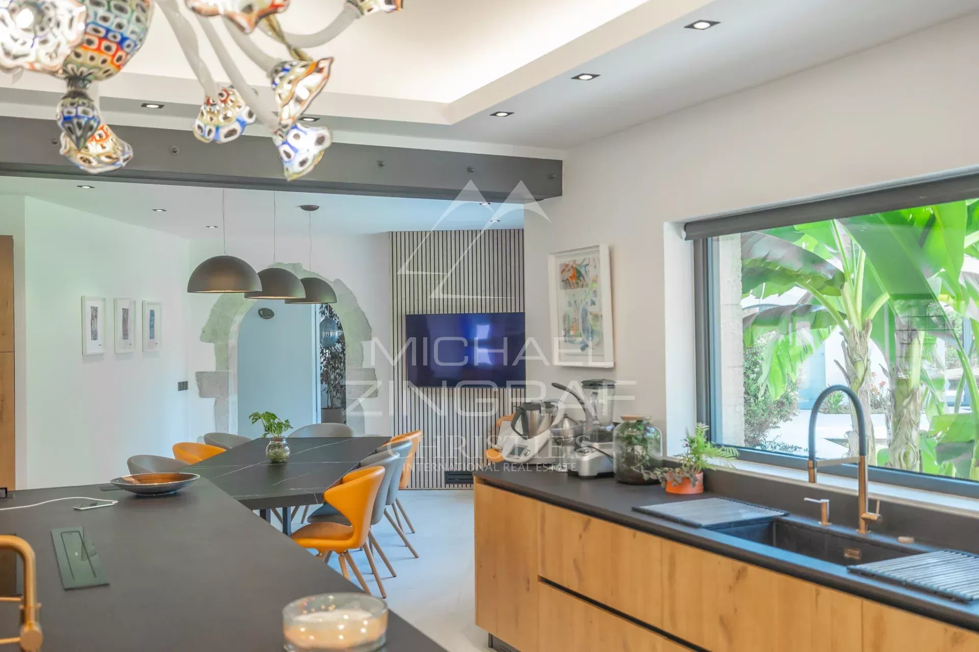 Modern kitchen in a renovated property Modern kitchen interior with a black worktop and colorful chairs.