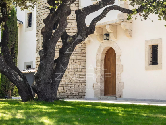 Entrance to a property with a tree and a stone facade in L'Isle-sur-la-Sorgue.