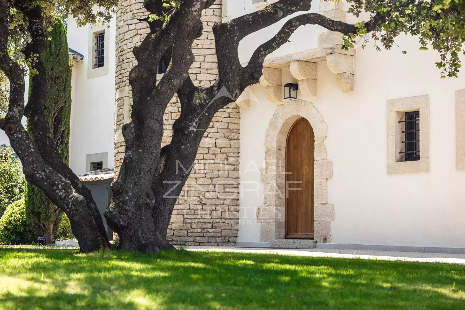 Exceptional property in L'Isle-sur-la-Sorgue Entrance to a property with a tree and a stone facade in L'Isle-sur-la-Sorgue.