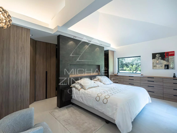 Modern room with double bed and wooden furniture, natural light through the windows.