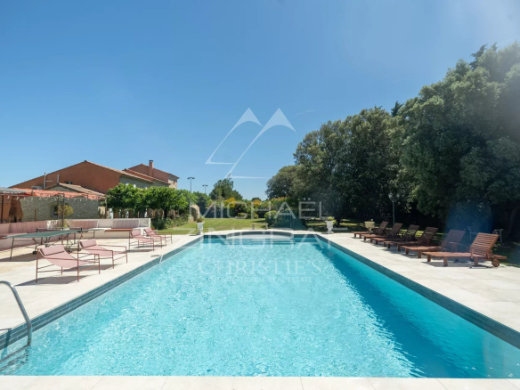 Piscine d'un mas en pierre avec chaises longues et jardins, Cavaillon