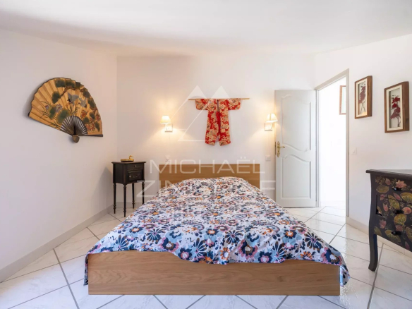 Chambre d'un mas en pierre avec lit et décoration intérieure à Cavaillon.