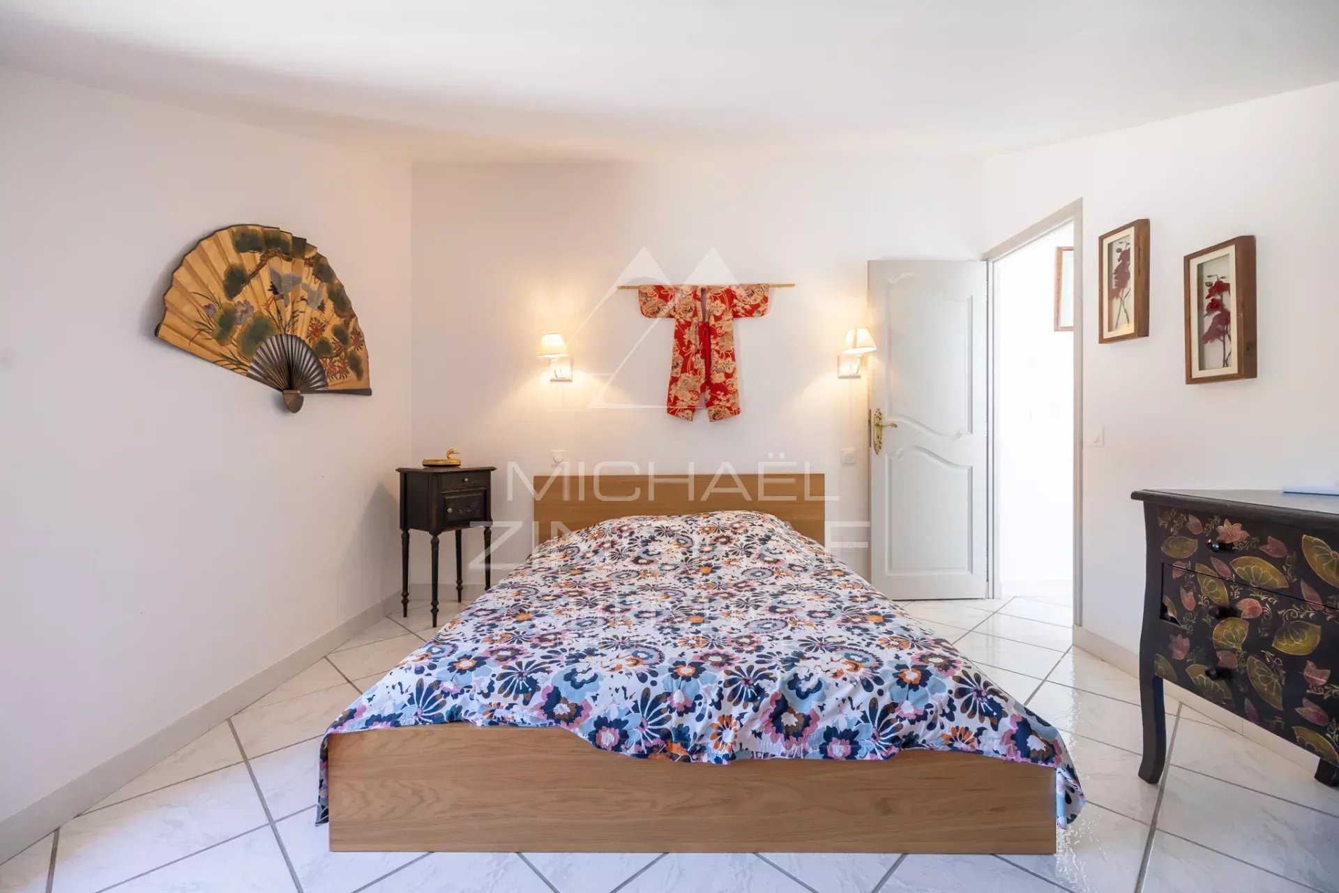 Chambre d'un mas en pierre avec lit et décoration intérieure à Cavaillon.