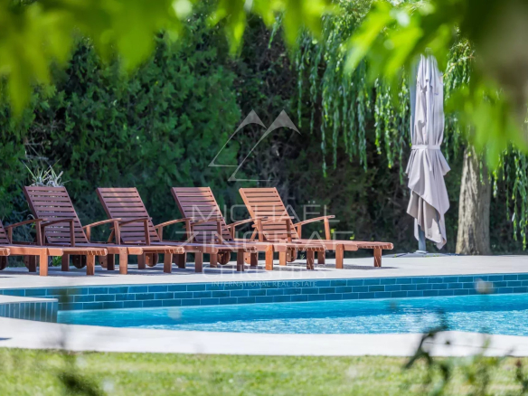 Terrasse avec chaises longues autour d'une piscine dans un mas en pierre